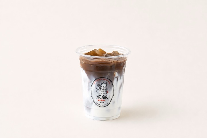Iced roasted hojicha latte poured through milk in a clear Kyo Kitsune cup