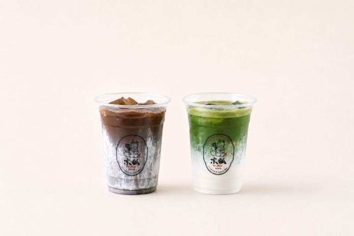 Iced hojicha and matcha lattes side by side in Kyo Kitsune cups