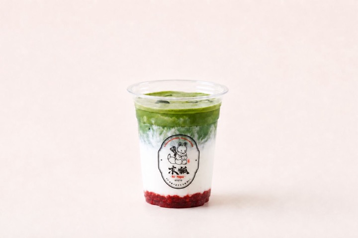 Layered matcha and strawberry latte with a deep red strawberry base